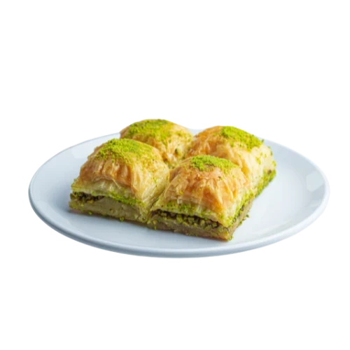 Baklava-Stücke mit besonders dicker Schicht gemahlener grüner Pistazien auf weißem Teller