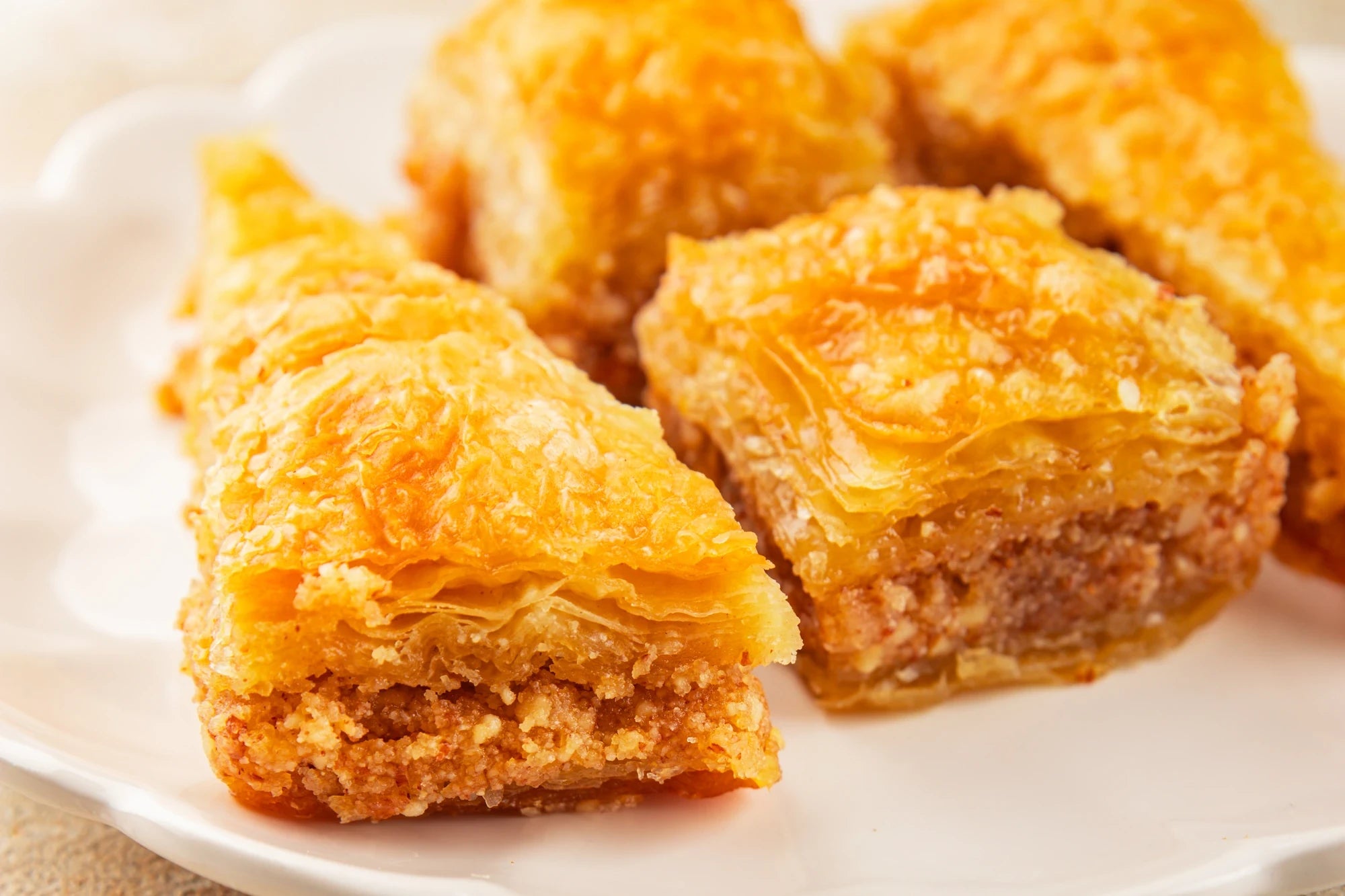 Goldbraune Şöbiyet-Baklava in Dreiecksform mit Grieß-Sahne-Füllung auf weißem Teller