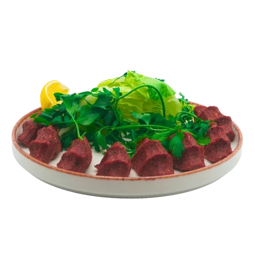 Vegane Çiğ Köfte aus Bulgur mit frischem Salat und Zitrone auf einer Servierplatte