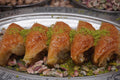 Fıstık Burma – gedrehte Baklava-Rollen mit Pistazien, in einer Reihe angerichtet