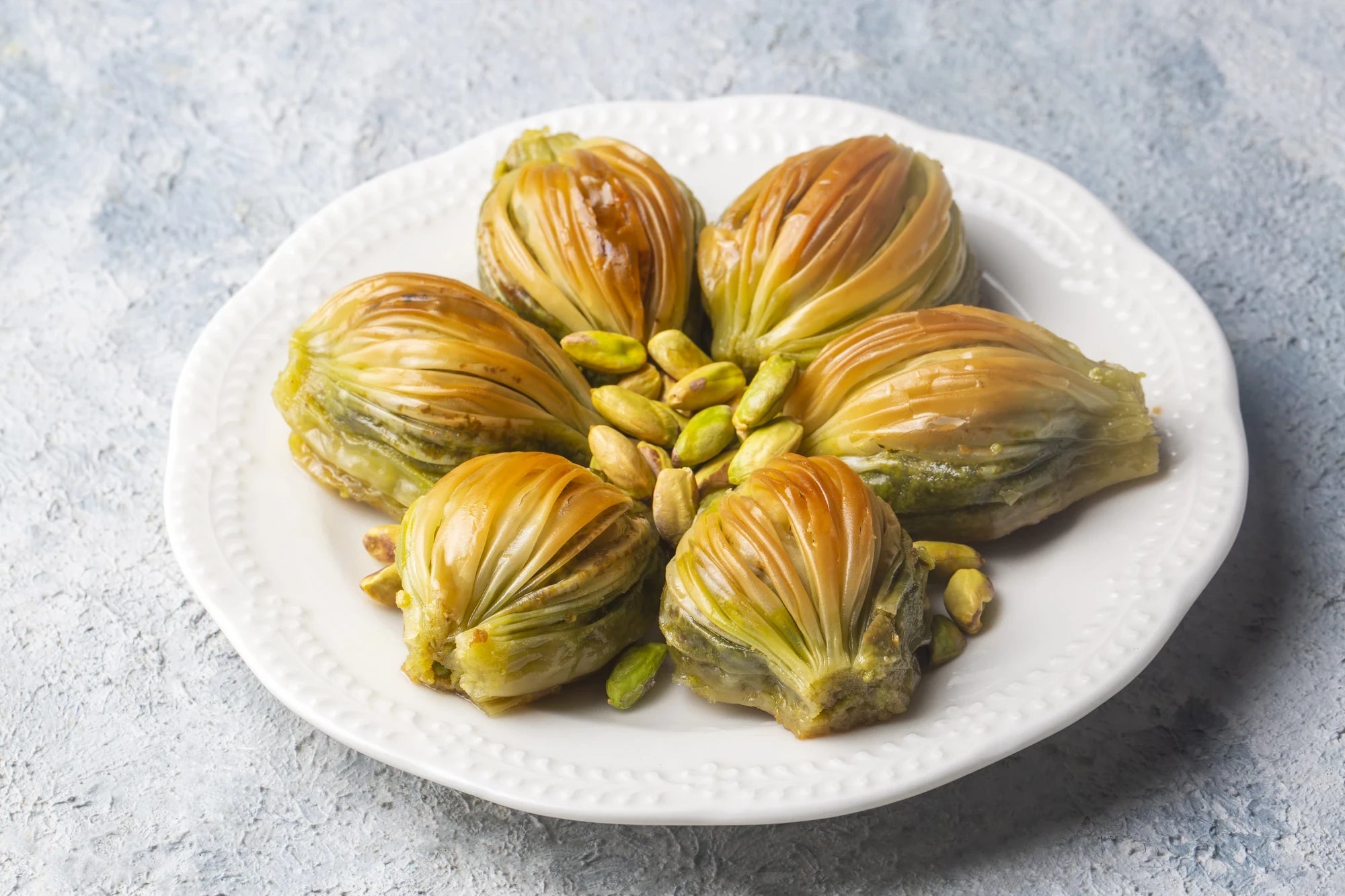 Bülbül Yuvası – nestförmige Baklava mit Pistazien in der Mitte, auf weißem Teller
